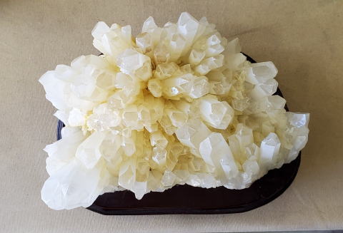 淡いクリーム色した水晶の結晶が針の山のようにぎっしり密集したクラスター